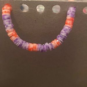 This is a orange and white and purple bracelet.